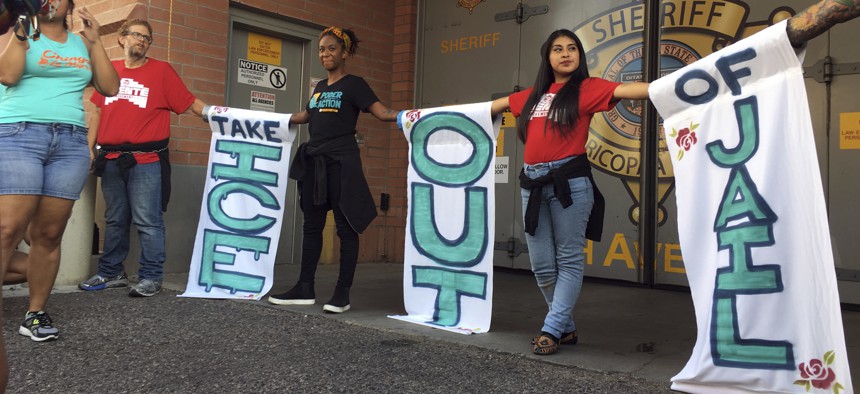A group of protesters chain themselves to each other outside the Maricopa County Jail in downtown Phoenix during a protest against the sheriff's relationship with Immigration and Customs Enforcement, Aug. 22, 2018.