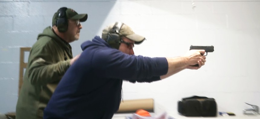In this photo taken from a video shot on Nov. 28, 2018, a man fires a gun at the American Tactical Systems' indoor range in Green Island, New York. 