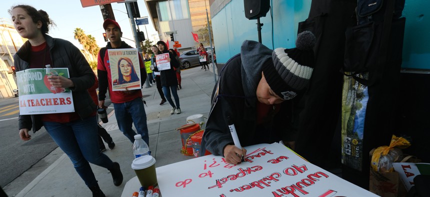 Rosa Companioni prepares a rally sign in support of Los Angeles school teachers Tuesday, Jan. 22, 2019, in Los Angeles.