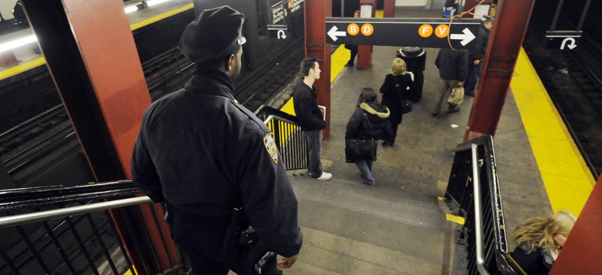 A New York police officer walks down stairs toward a subway platform, in midtown Manhattan.