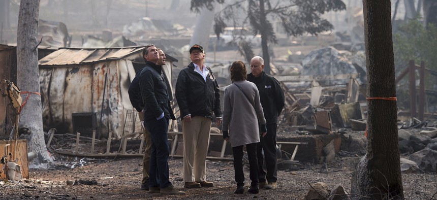 Gov.-elect Gavin Newsom, FEMA Director Brock Long, President Donald Trump, Paradise mayor Jody Jones and Gov. Jerry Brown tour the Skyway Villa Mobile Home and RV Park, during Trump's visit of the Camp Fire in Paradise, Calif. on Nov. 17, 2018. 