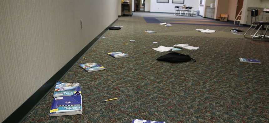 In this May 6, 2016, photo, books and supplies litter the floor as a class evacuated the area during an intruder drill at Forest Dale Elementary School in Carmel, Ind.