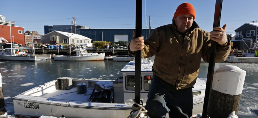 Lobsterman Jim Buxton climbs up from a dock where after checking on the bilge pump on his lobster fishing boat during frigid temperatures, Thursday, Jan. 31, 2019, in Portland, Maine.