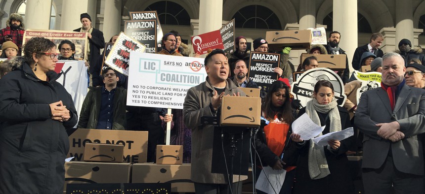 This Dec. 12, 2018 file photo shows State Assemblyman Ron Kim, center, as he speaks at a rally opposing New York's deal with Amazon, on the steps of New York's City Hall. 