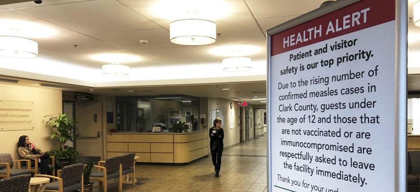 In this Jan. 25, 2019 file photo, a sign prohibiting all children under 12 and unvaccinated adults stands at the entrance to PeaceHealth Southwest Medical Center in Vancouver, Wash.