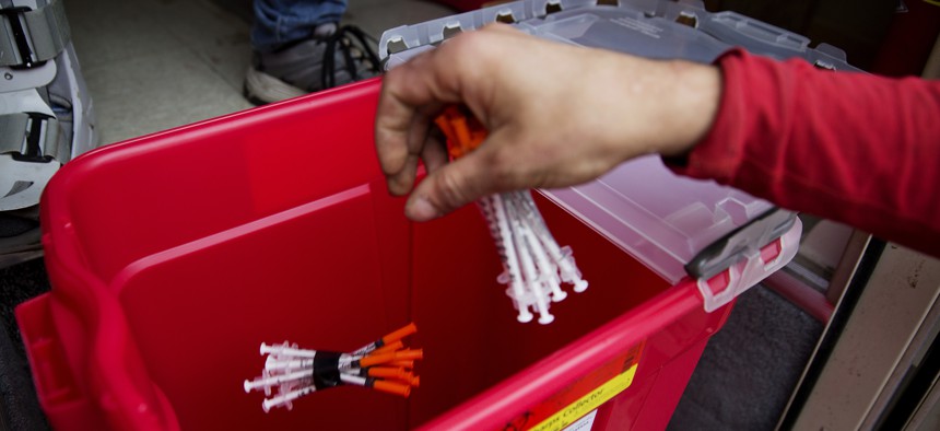 A person deposits used needles into a bin during a needle exchange program run by the Grays Harbor County Public Health and Social Services Department in Aberdeen, Wash., on June 14, 2017.
