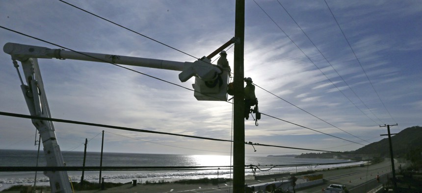 Crews from Southern California Edison work on damaged power lines. The utility and several others in the state are required to switch to time-of-use pricing, which charges more when electricity is costlier to produce.