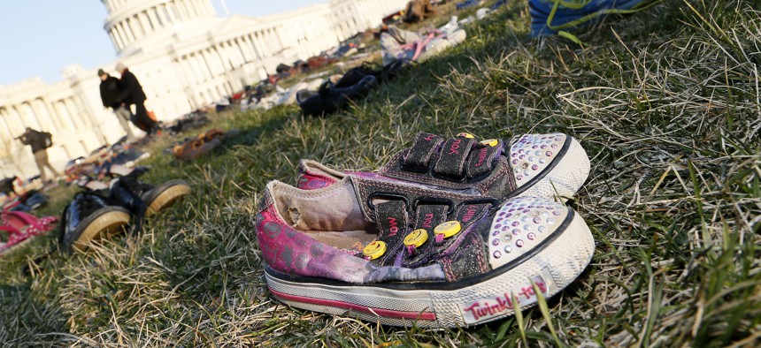 In front of the U.S. Capitol building, survivors, family members and volunteers place 7,000 empty pairs of shoes for every child killed by guns in the U.S. since Sandy Hook on March 13, 2018.