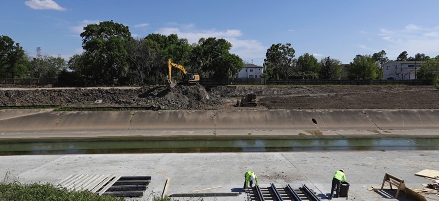 Construction workers excavate and widen Brays Bayou as part of a nearly $500 million flood control project on March 22, 2018, in Houston. 