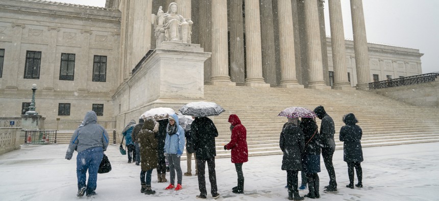 Visitors wait to enter the Supreme Court Wednesday as a winter snow storm hits the nation's capital. The court that morning ruled in the case of an Indiana man whose Land Rover was seized by police. 