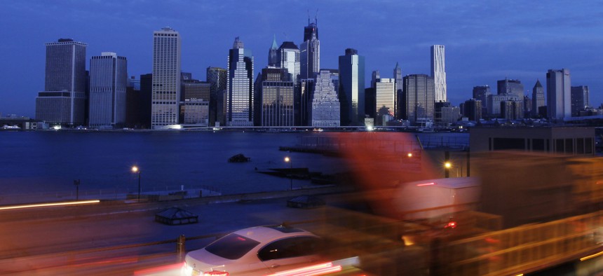 Early morning traffic in New York's Brooklyn borough moves slowly beneath the Manhattan skyline.
