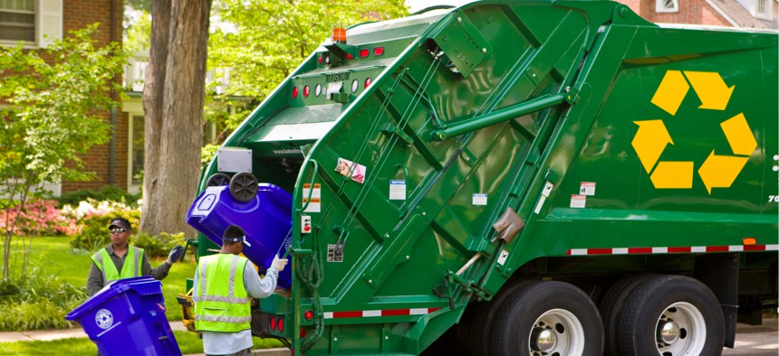 Workers empty recycling bins into a truck in Arlington, Virginia