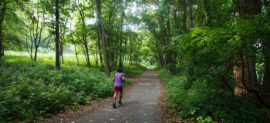 In this July 7, 2016 photo, a runner strides along the cross country course at Van Cortlandt Park in the Bronx borough of New York.