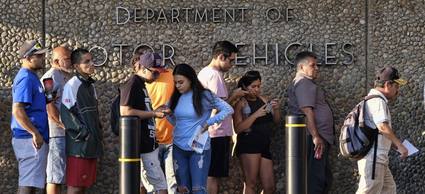  In this Aug. 7, 2018, file photo, people line up at the California Department of Motor Vehicles prior to opening in the Van Nuys section of Los Angeles.