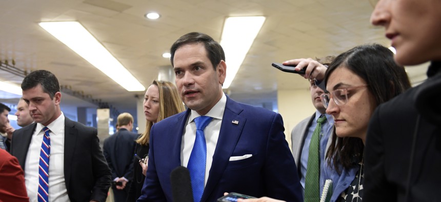 Sen. Marco Rubio, R-Fla., center, is followed by reporters on Capitol Hill in Washington.