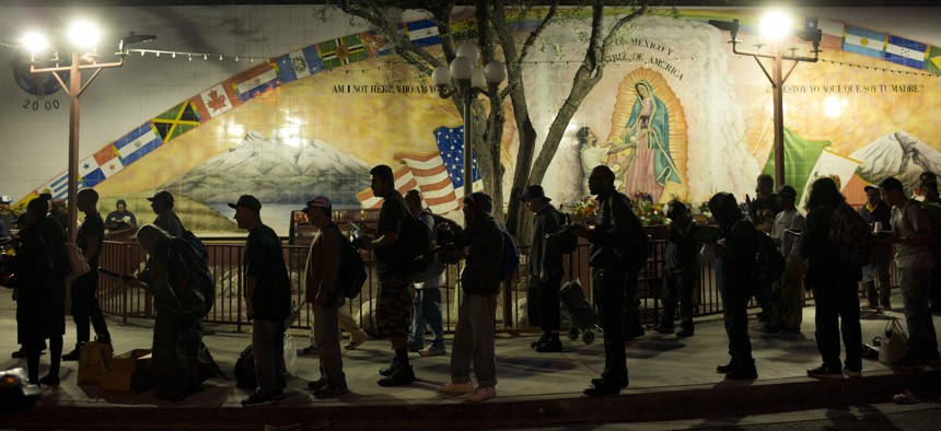 Homeless people wait in line for a meal served by a community organization outside Our Lady Queen of Angels Catholic Church in Los Angeles.