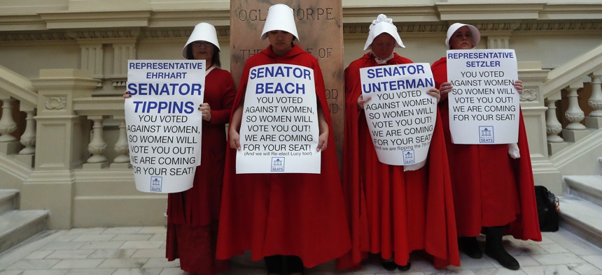 Women hold signs to protest HB 481 in April at the state Capitol in Atlanta. HB 481, which would ban most abortions after a fetal heart beat is detected, was signed by Gov. Brian Kemp in May.