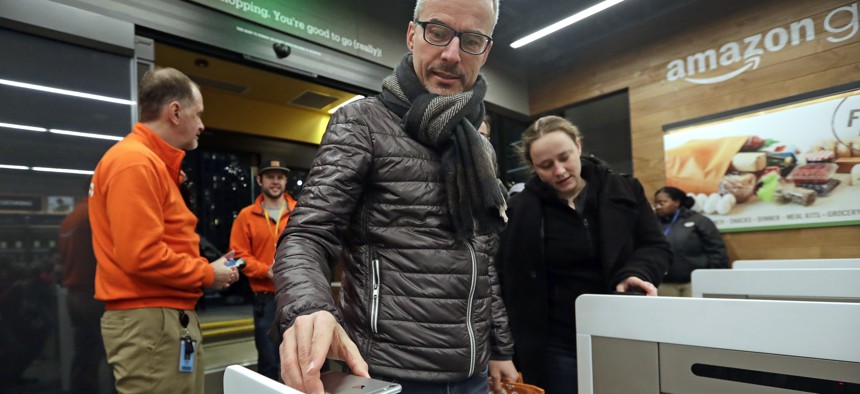 A customer scans his phone app at the entrance to an Amazon Go store in Seattle.