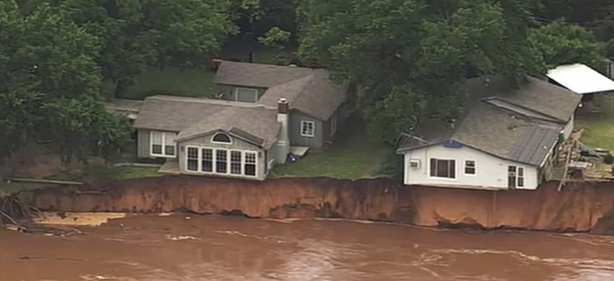This image taken from video provided by KOCO-5 shows homes dangerously close to the Cimarron River on May 22, 2019 near Crescent, Oka.