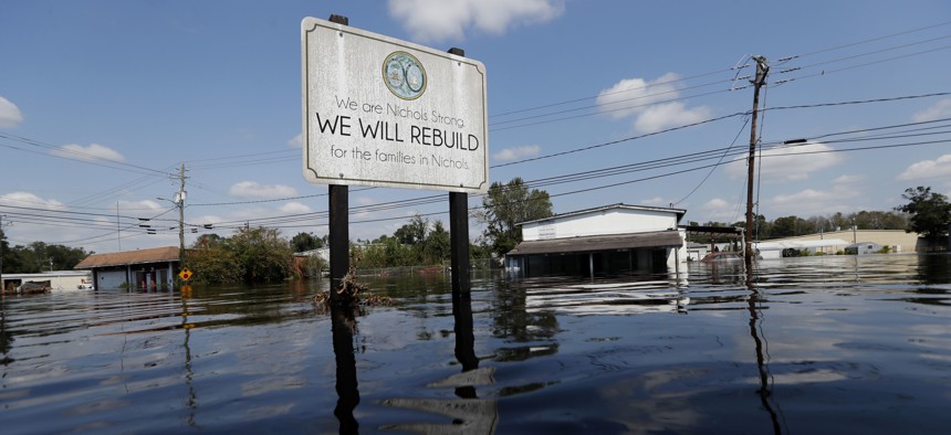 A sign commemorating the rebuilding of the town of Nichols, which was flooded two years earlier from Hurricane Matthew, stands in floodwaters in the aftermath of Hurricane Florence in Nichols, S.C. in 2018. 