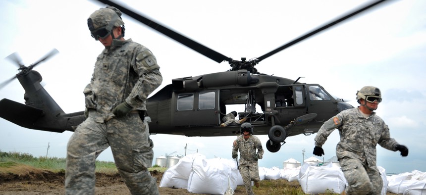 Missouri National Guard soldiers airlift sandbags to reinforce a levee.