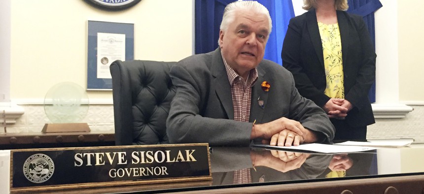 Nevada Gov. Steve Sisolak sits at his desk at the Capitol in Carson City in May. Sisolak says he plans to sign legislation expanding collective bargaining rights for public workers in the state.