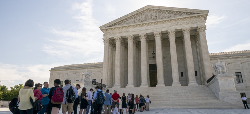 Visitors line up at the Supreme Court in Washington as the justices prepare to hand down decisions, Monday, June 17, 2019.