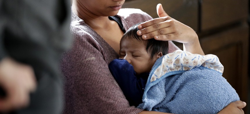 A mother holds her one-month old son during a medical checkup after being released from a Border Patrol facility.