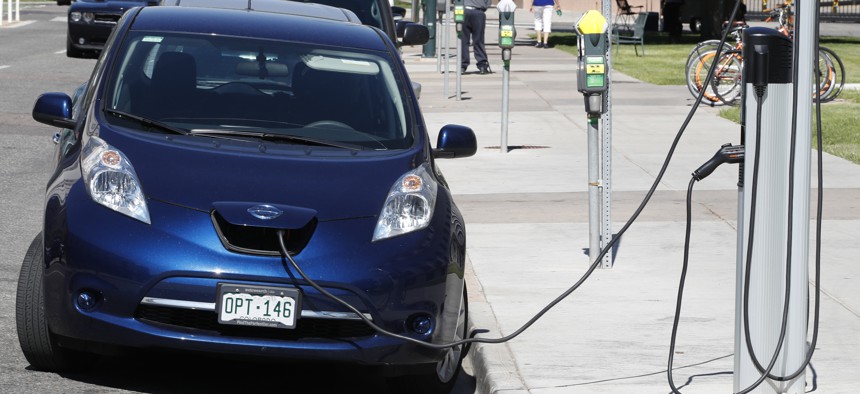 A Nissan Leaf charges at a recharge station while parked by the Denver City/County Building in downtown Denver. 