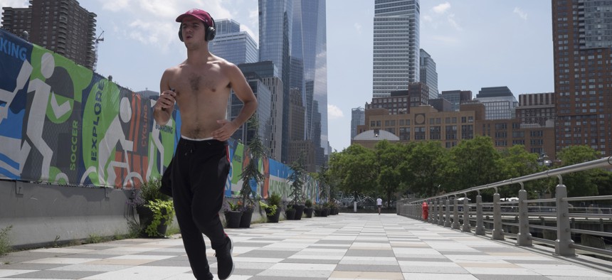 A shirtless man runs along the Hudson River Walkway during a July 2019 heat wave in New York, NY. 