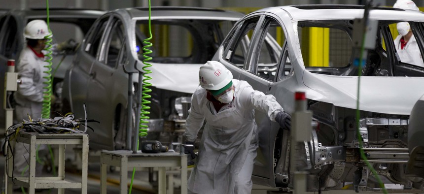 In this Feb. 21, 2014 file photo, employees at work in the new multibillion-dollar Honda car plant in Celaya, in the central Mexican state of Guanajuato.