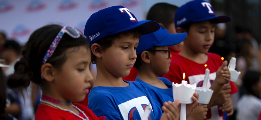 Children of a youth sports community participate in a vigil for the victims of Saturday's mass shooting in El Paso, Texas, Sunday, Aug. 4, 2019.