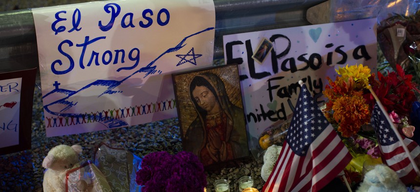 A Virgin Mary painting, flags and flowers adorn a makeshift memorial for the victims of Saturday's mass shooting at a shopping complex in El Paso, Texas, Sunday, Aug. 4, 2019.