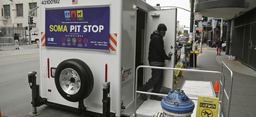 An attendant exits a "Pit Stop" public toilet on Sixth Street in San Francisco.