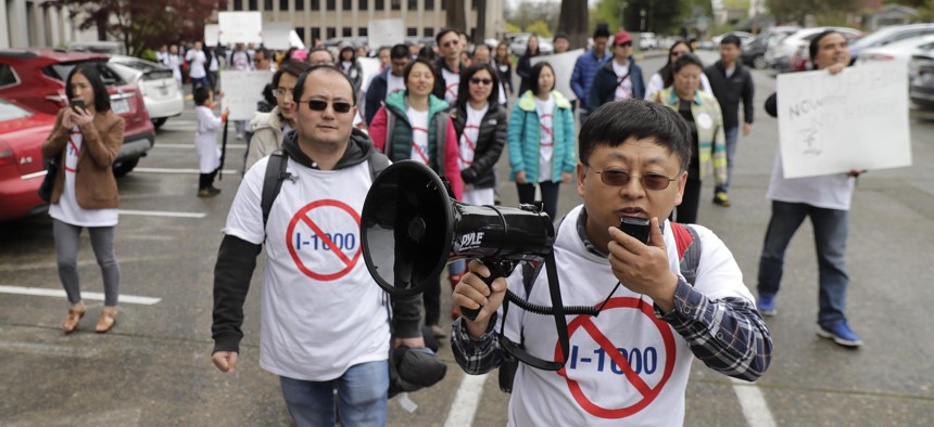 Protesters opposed to Initiative 1000 chant and march following a joint Washington state House and Senate committee, Thursday, April 18, 2019, at the Capitol in Olympia, Wash. 