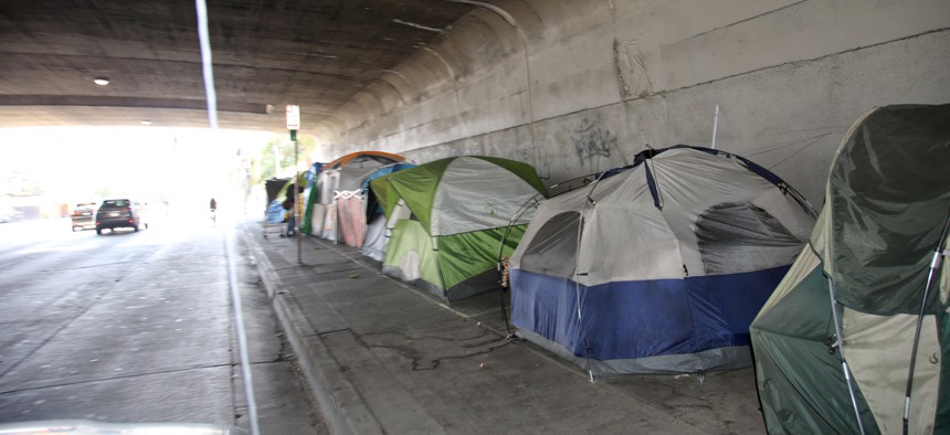 A row of tents stationed under a viaduct in LA.