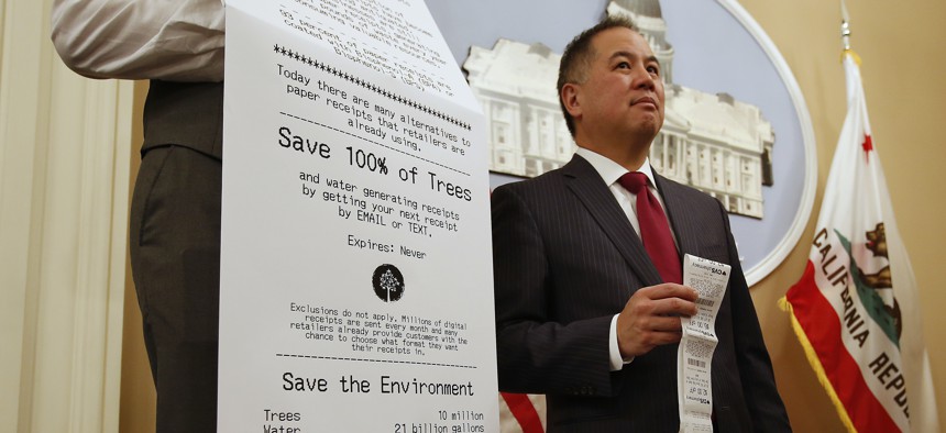 State Rep. Phil Ting, D-San Francisco, displays a long paper receipt as he discusses his bill to require businesses to offer electronic receipts.