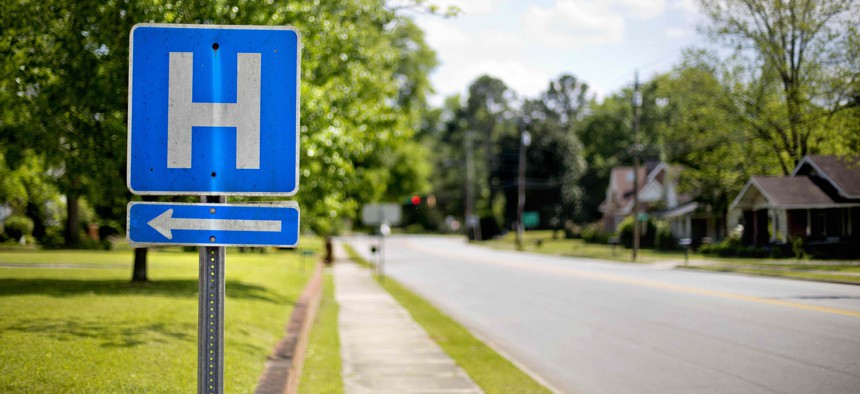 In this April 25, 2014 photo, a sign points the way to Flint River Hospital which closed its emergency room in 2013, in Montezuma, Ga.