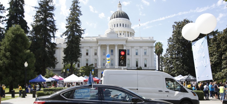 Dozens of supporters of a measure to limit when companies can label workers as independent contractors circle the Capitol during a rally in Sacramento, Calif., on Aug. 28, 2019. 