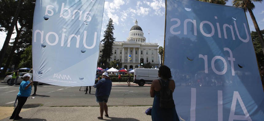 Supporters of California Assembly Bill 5 display banners in support of the bill during a rally at the Capitol in Sacramento, Calif., Wednesday, Aug. 28, 2019. 