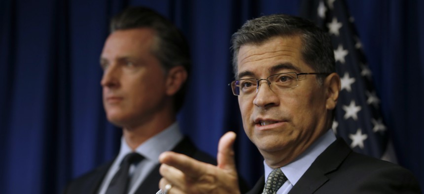 California Attorney General Xavier Becerra, right, flanked by Gov. Gavin Newsom, responds to a question concerning the Trump administration's pledge to revoke California's authority to set vehicle emissions standards.