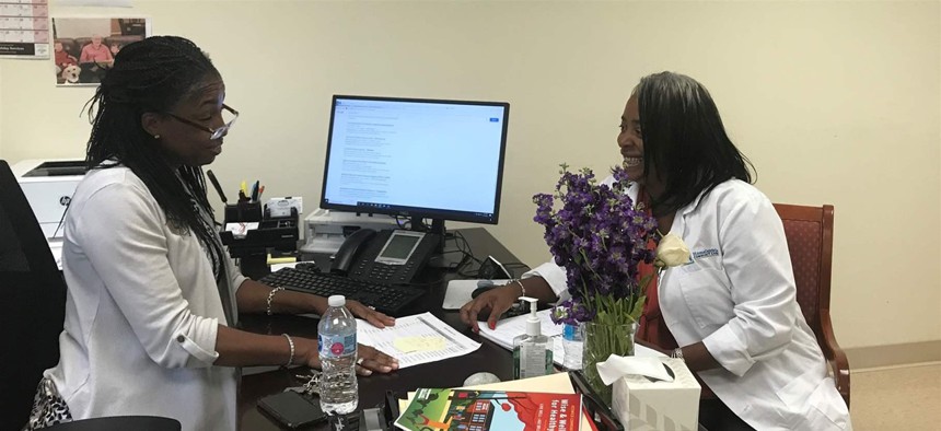 Lisa Mears-Morris, left, and Latonya Gwynn go over resident files at Weinberg Villages, a housing complex for low-income seniors in Owings Mills, Maryland. The two are part of a national experiment aimed at helping seniors age in place.