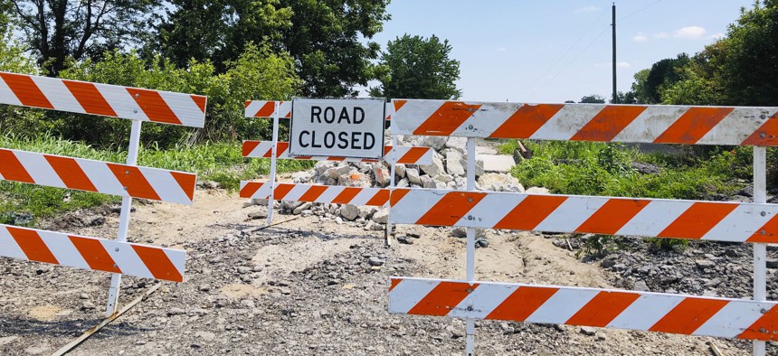 In this July 27, 2019, photo, signs block access to a bridge on a rural road in Callaway County, Missouri, on July 27, 2019. The road's approach to the bridge was washed out by flooding that began in late May and extended into early July. 