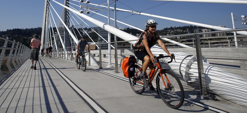 Runners and cyclists make their away across the Tilikum Crossing, a bridge in Portland, Ore.