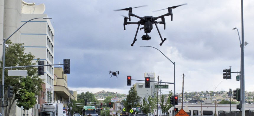 In this May 21, 2019 photo, two drones fly above Lake Street in downtown Reno, Nev., as part of a NASA simulation to test emerging technology.