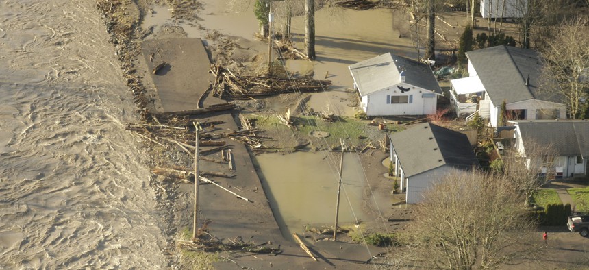The Puyallup River flows near flooded homes near Puyallup, Washington, in 2009. Communities across Washington are removing human development rather than engineering bigger and costlier fixes to the flooding.