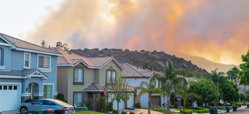 A wildfire burns near homes in Corona, California.