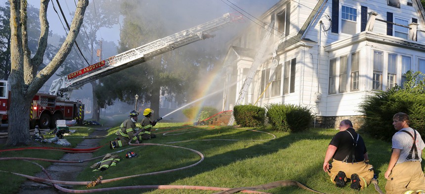 Firefighters battle a house fire, Thursday, Sept. 13, 2018, in North Andover, Mass., one of multiple emergency crews responding to a series of gas explosions and fires triggered by a problem with a gas line that feeds homes in several communities.