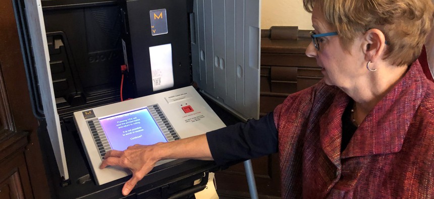 In this Sept. 25, 2019 photo, Indiana Secretary of State Connie Lawson demonstrates an upgraded voting machine on Wednesday, Sept. 25, 2019, at the Indiana Statehouse office in Indianapolis. 