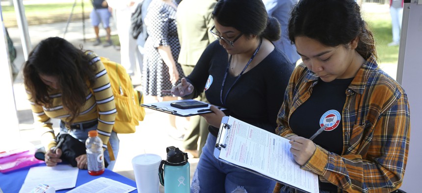 Arizona students fill out voter registration forms at Phoenix College on National Voter Registration Day Tuesday, Sept. 24, 2019.